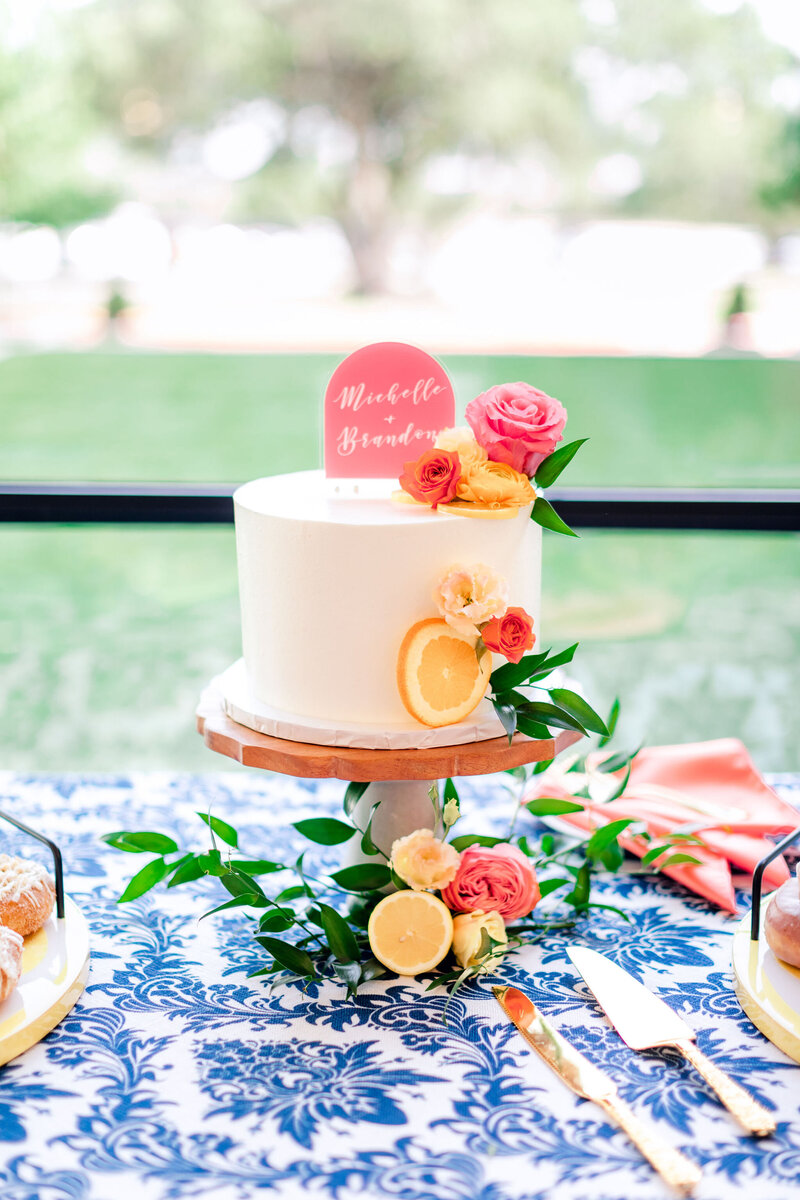 wedding cake with orange slices and pink + orange roses