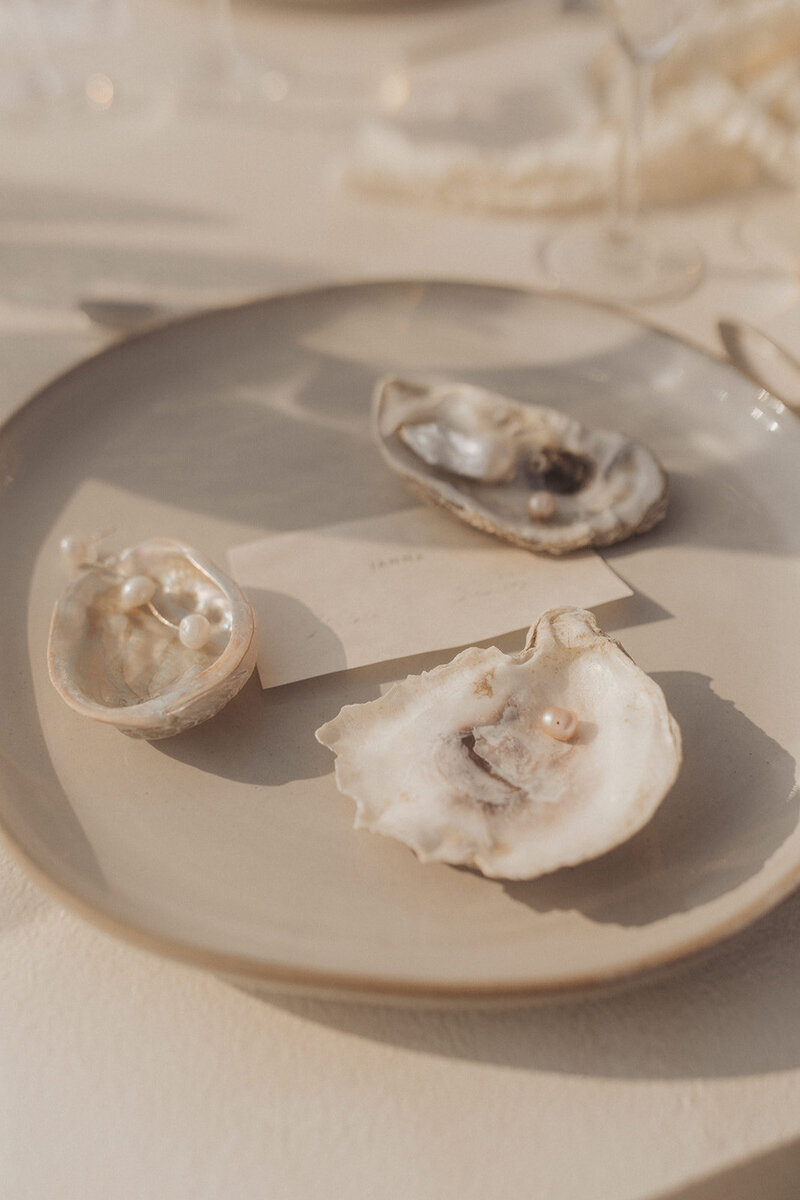 Pearls in seashells on a plate, with an elegant, blurred background.