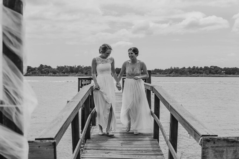 Two brides walking on a dock