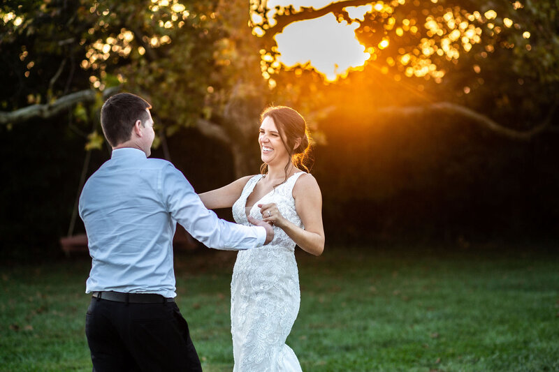 Bride and groom dance in the grass during sunset, Bohemia Overlook Wedding
