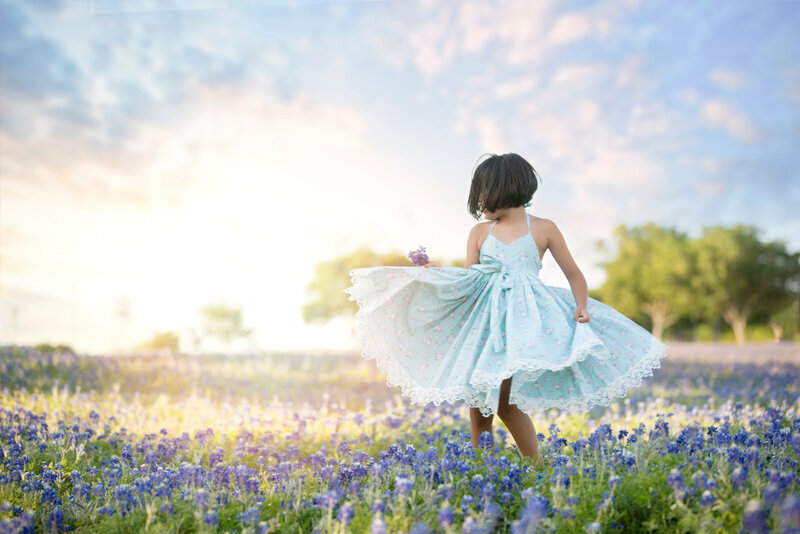 Girl twirling in Dallas bluebonnet field.