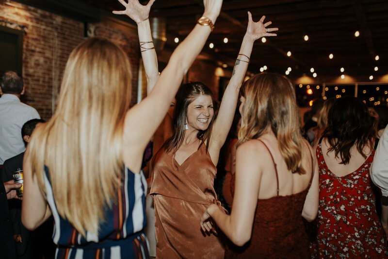 wedding guests dancing with hands in the air