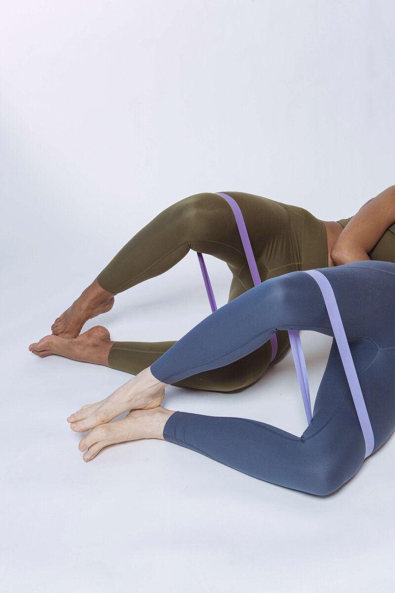 Two women using exercise band to stretch