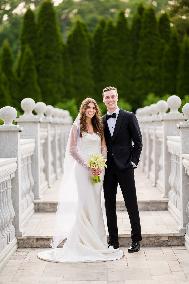 A bride and groom, standing on a bridge on the grounds of the mansion on Main Street in New Jersey