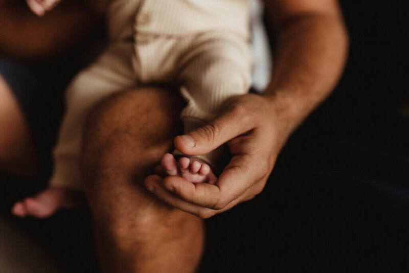 newborn foot in hand baby close up
