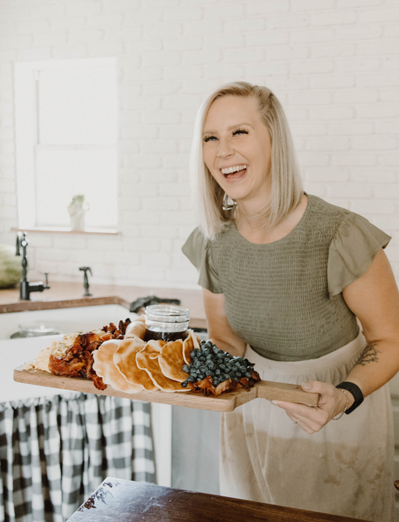 Leslie Burris holding a breakfast charcuterie board laughing