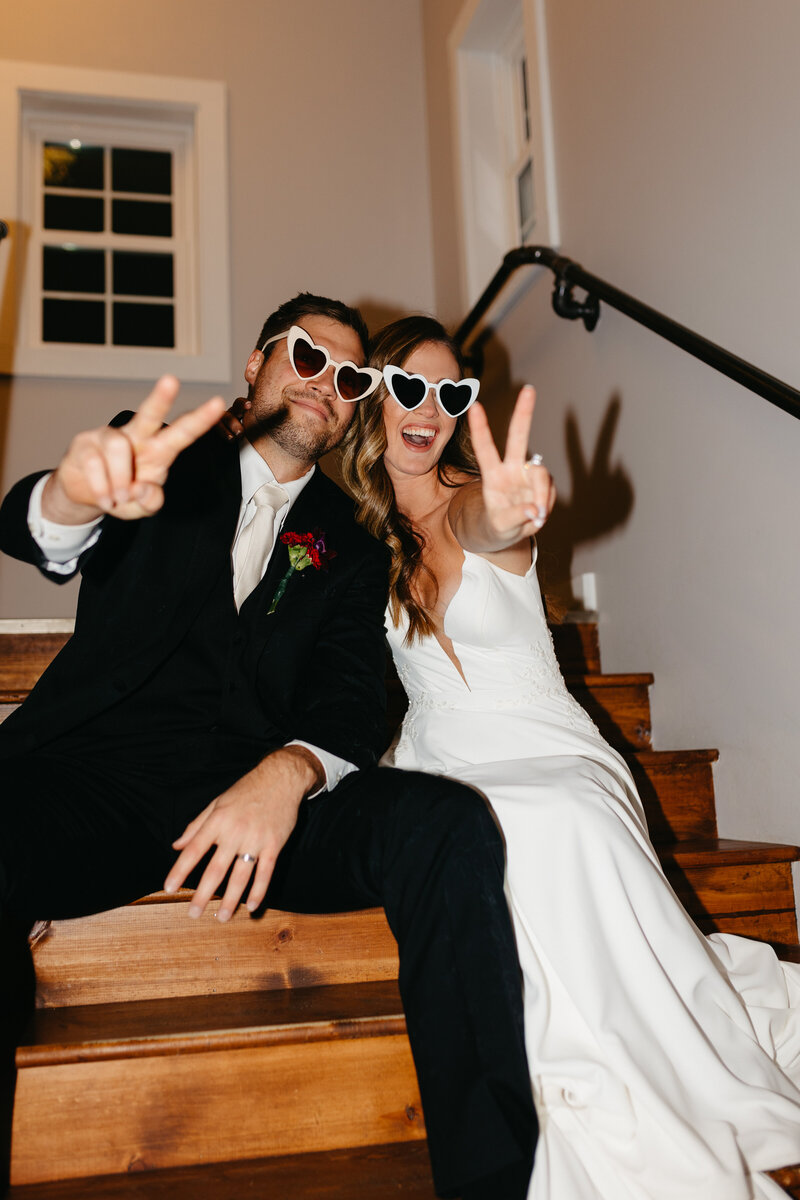 couple showing peace sign with  heart glasses on wedding day