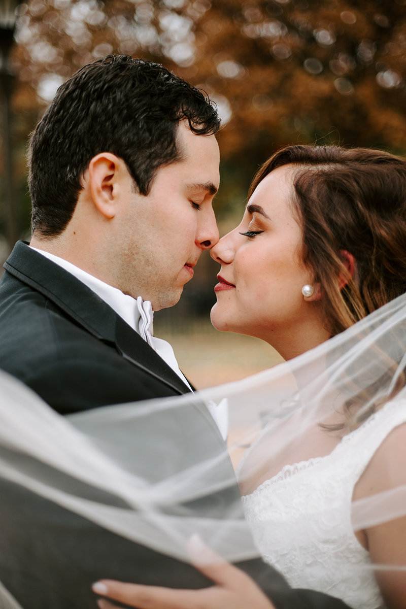 Bride and Groom veil blowing in the wind snuggling on their Minneapolis Wedding day