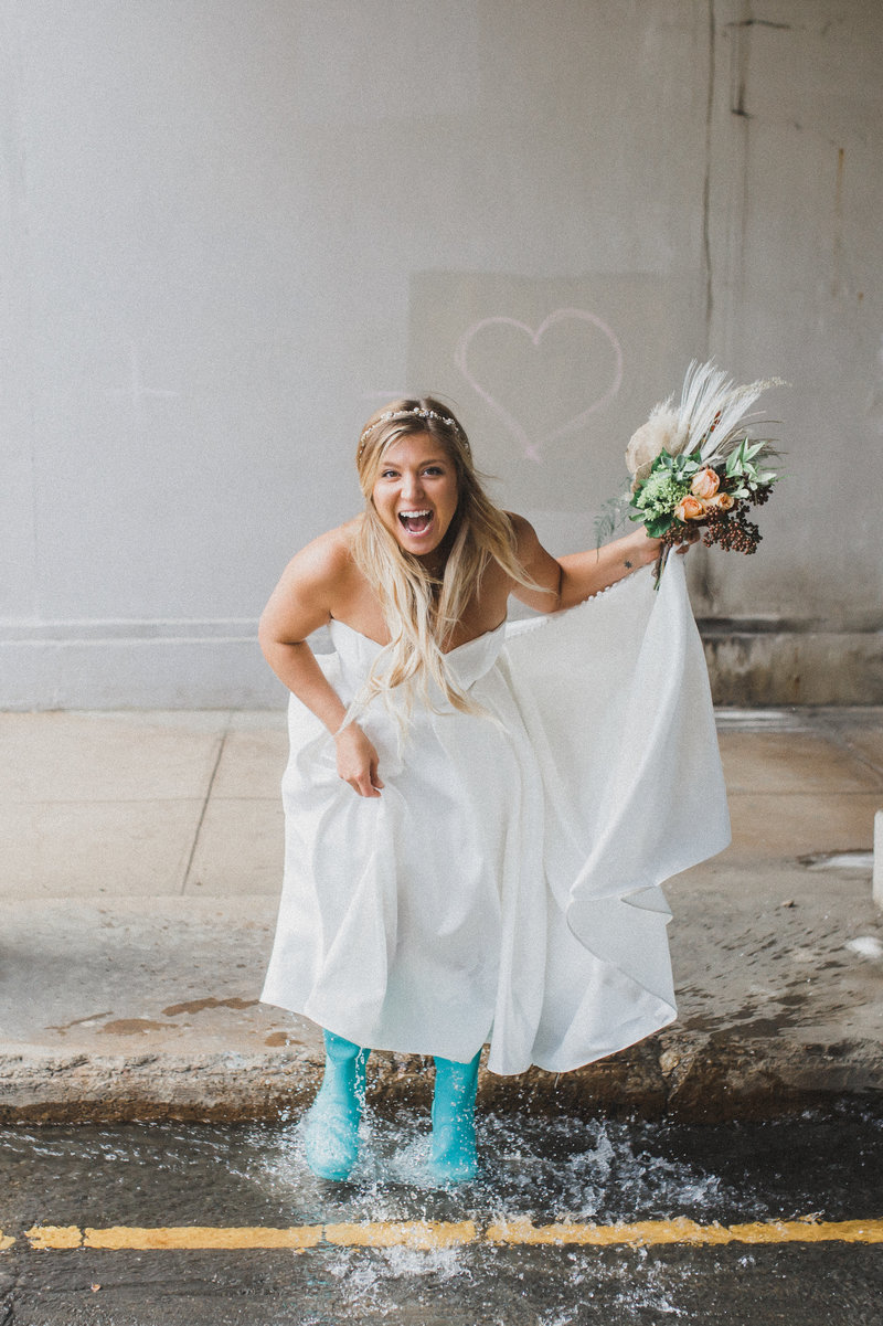 bride jumping in street puddle