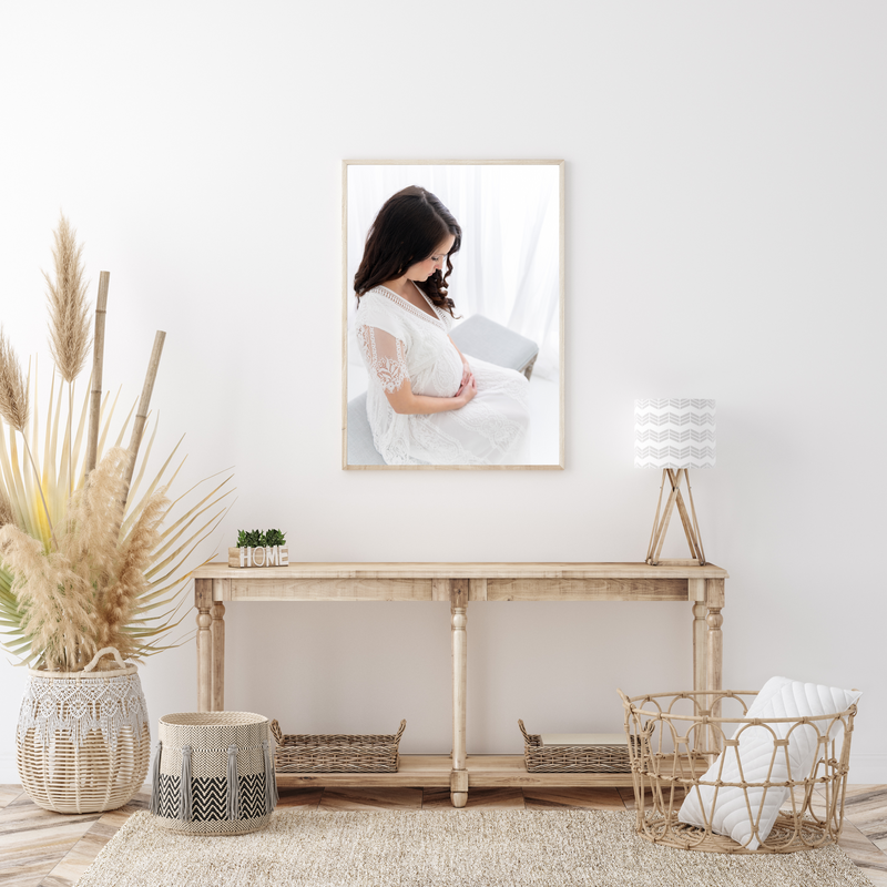 A fine art maternity photograph print hands on a wall above a desk