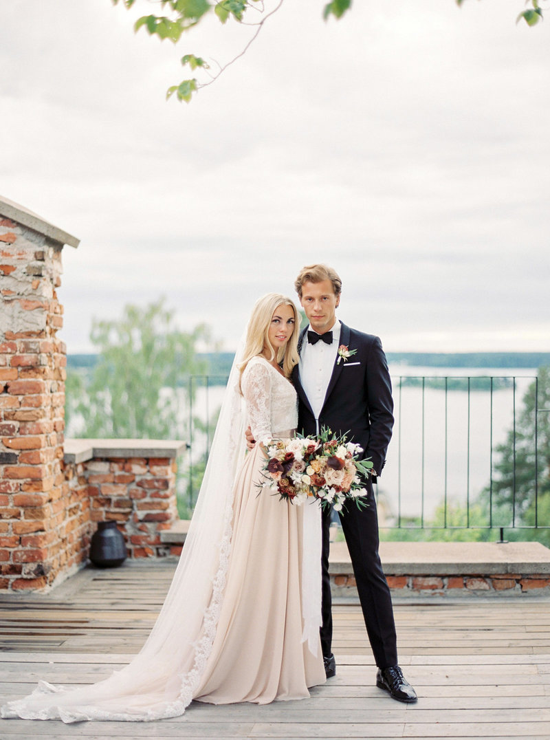 Brud och brudgum poserar för sin fotograf på Ruin Retreat i Stockholm
