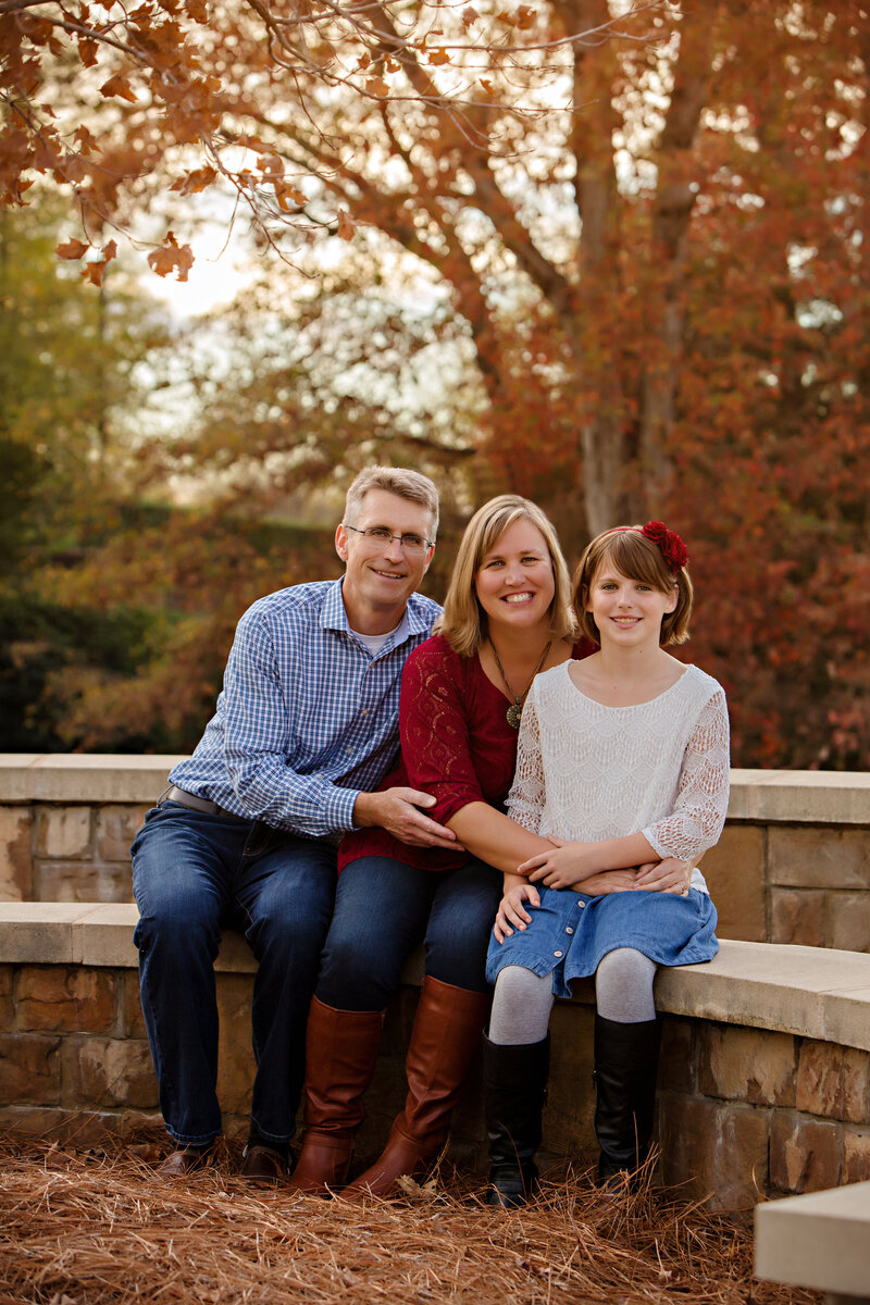 Carolyn Ann Ryan captured this adorable photo of a family of 3  including Dad, Mom and daughter wearing a combination of blue and cranberry colors.