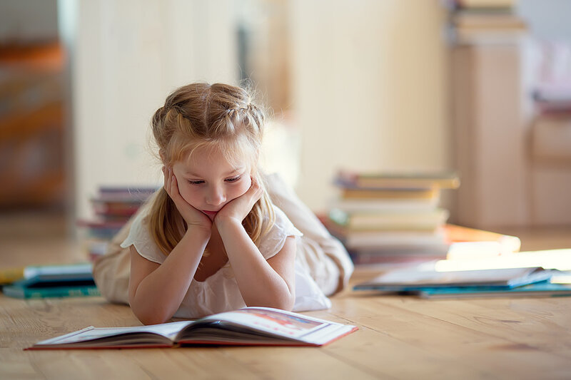 student reading while laying on floor
