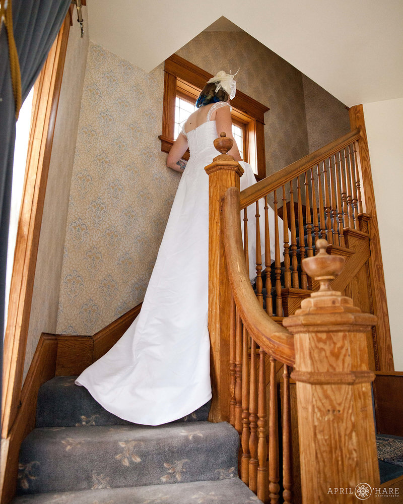 Bride walks up the stairs inside a vintage house wedding venue called McCreery House in Loveland Colorado