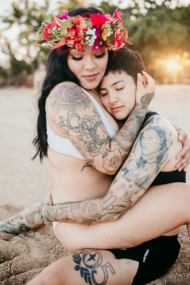 Same sex couple hugging in Hawaii beach