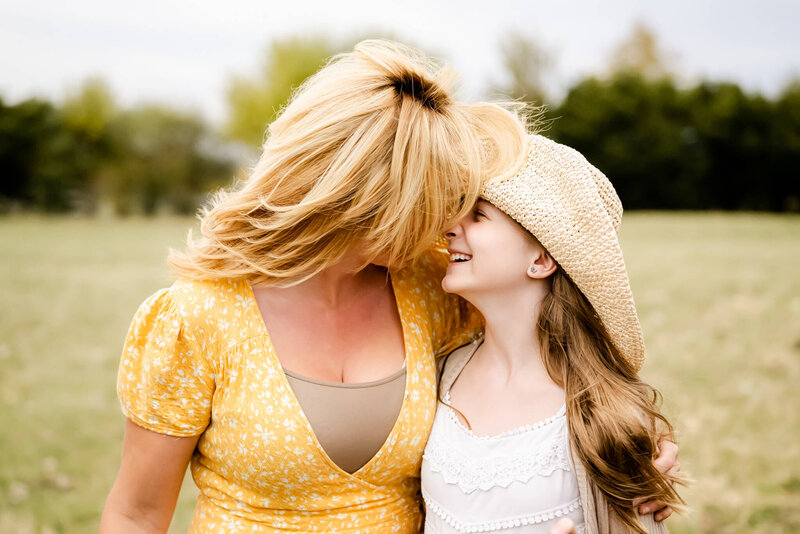 Mother and daughter touching foreheads at family photo session at Sunset Farm in Bartlett, IL.