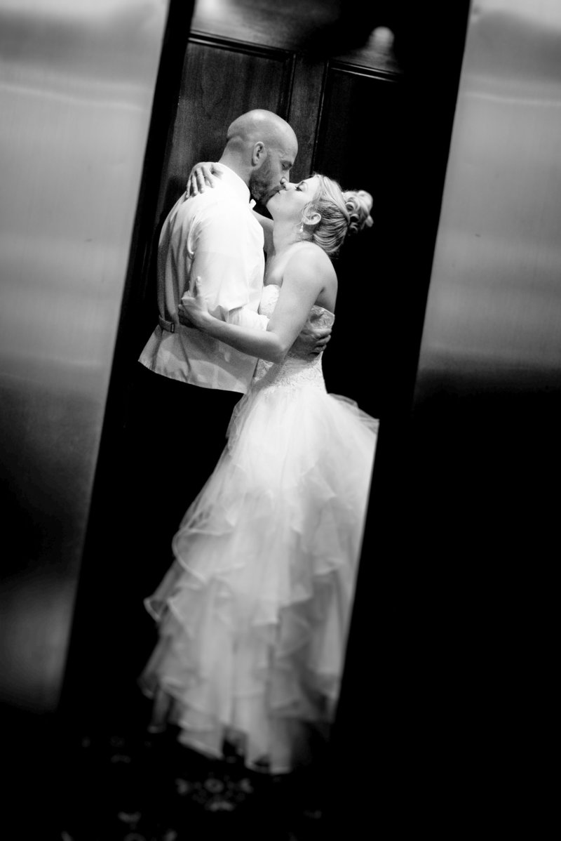 A couple shares an embrace while the elevator doors close