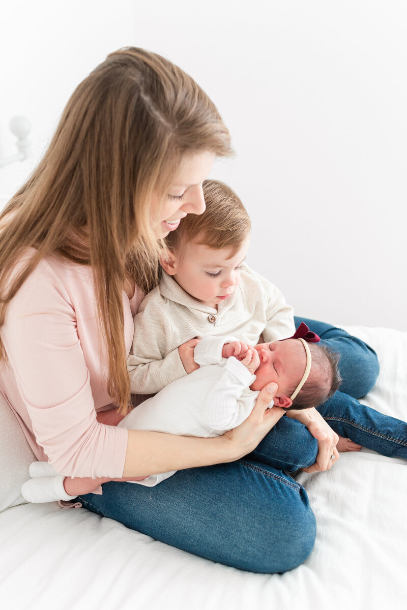 A mother holding her toddler son and newborn baby girl by northern va family photographer