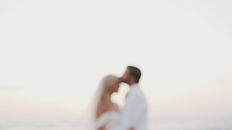 A bride and groom sharing a romantic beach kiss, captured by a talented Texas wedding videographer.