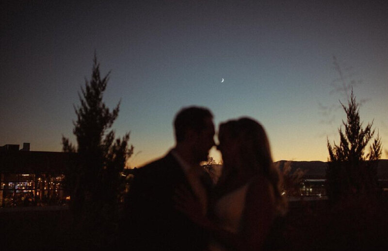 bride and groom kissing in the moonlight