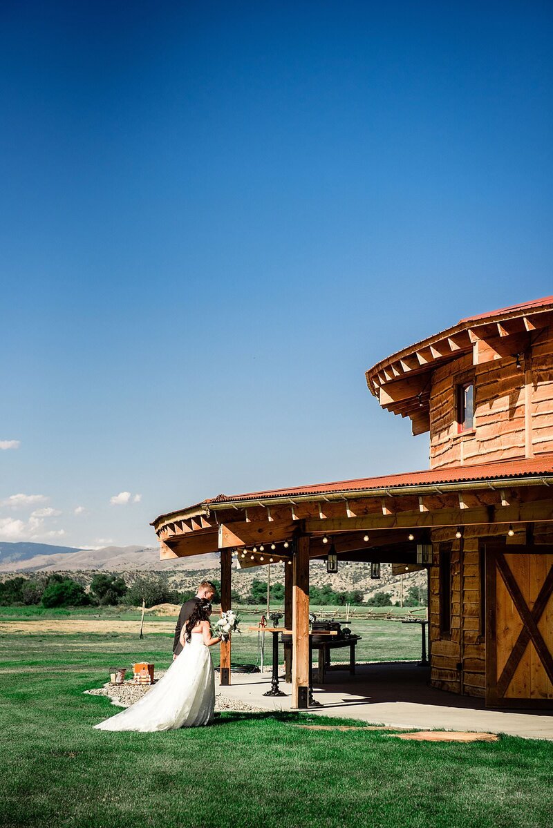 Bride and groom holding hands walking into the Headwaters Ranch barn