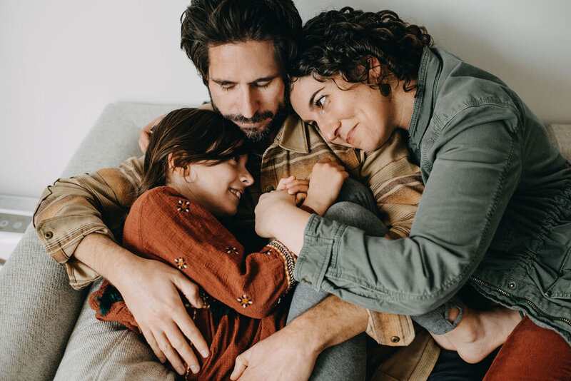 California family lifestyle portrait of Mom Dad daughter snuggling together at home