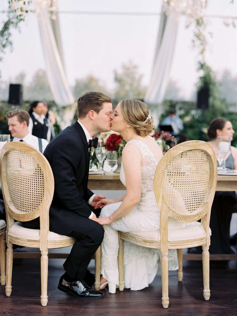 Bride and groom kiss at wedding reception