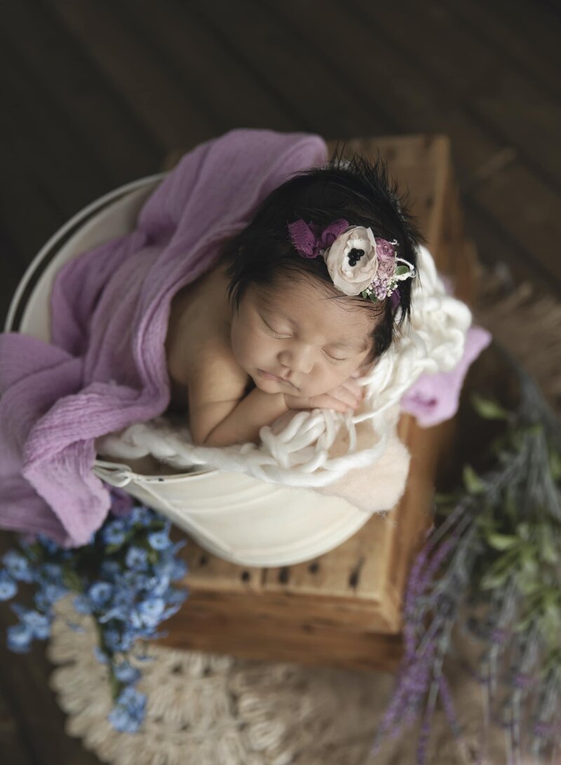 Newborn in blanket with blue knit bonnet