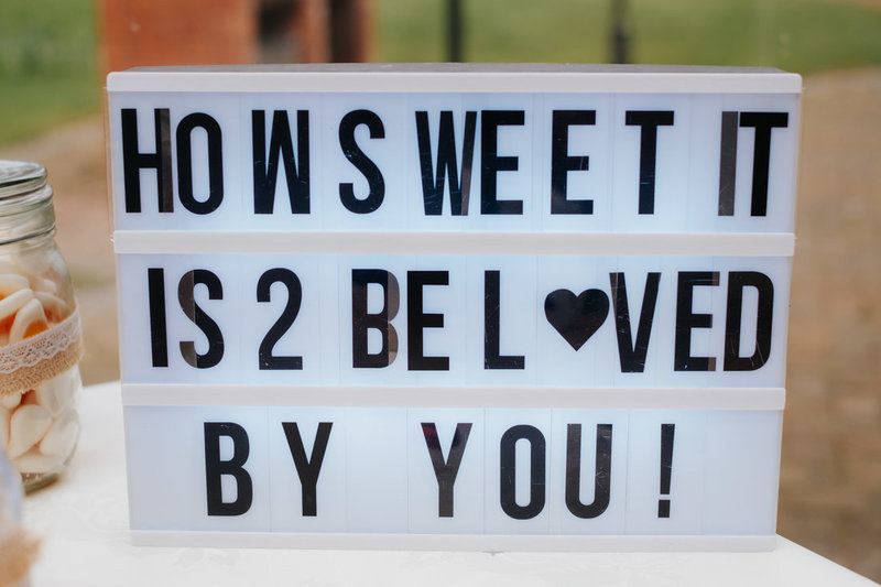 lightbox sign spelling out "how sweet it is to be loved by you"