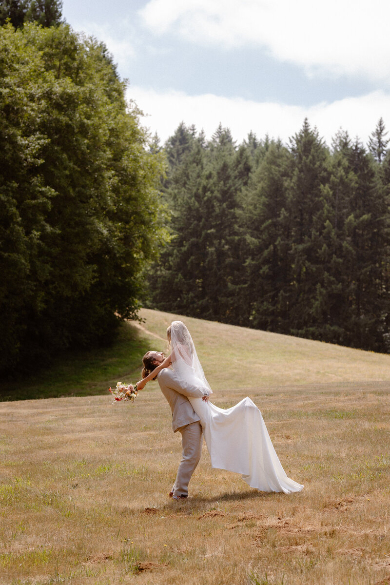bride and groom kissing in a grassy area