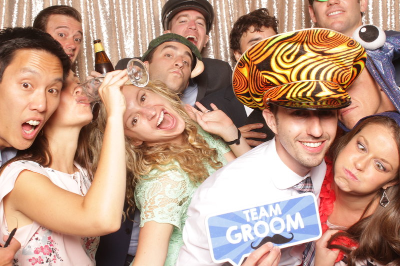 bride and groom with friends in open air photo booth