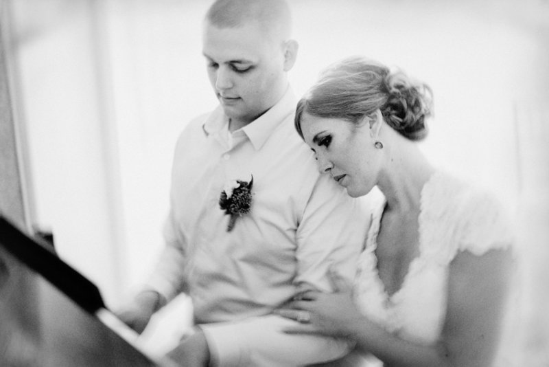 bride and groom at piano during wedding near Omaha