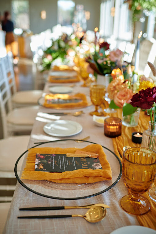 A vibrant mustard-yellow and black accented table with Dutch masterpiece inspired stationery is set for a wedding at Le Belvedere in Wakefield Quebec