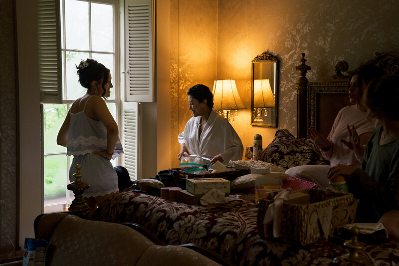 Bride preparing for her wedding day in warmly lit vintage room with Bridemaids – photographed by wedding photographer Niko Coric – Lumen Clarity Media