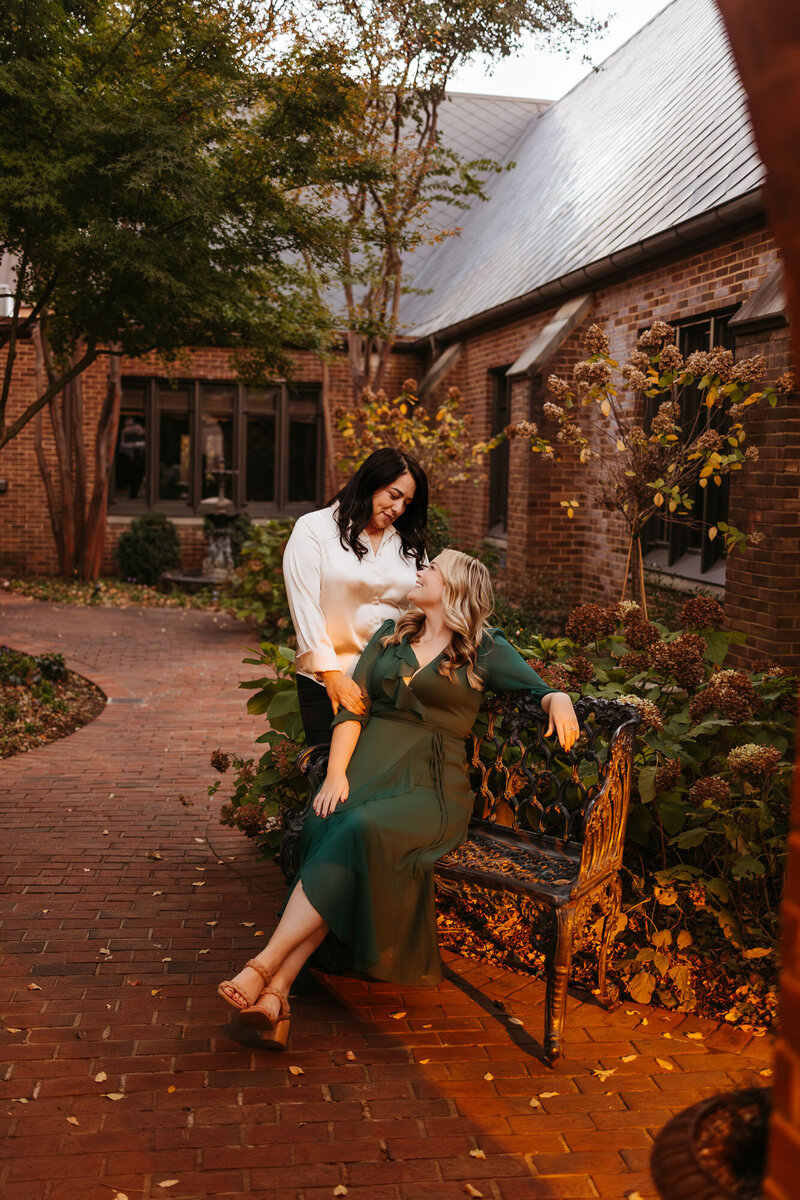 couple looking at each other lovingly near brick building
