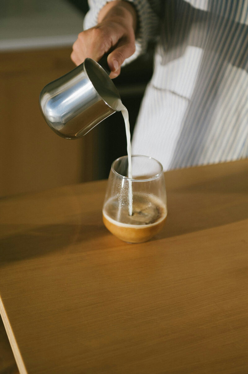 pouring milk in a coffee