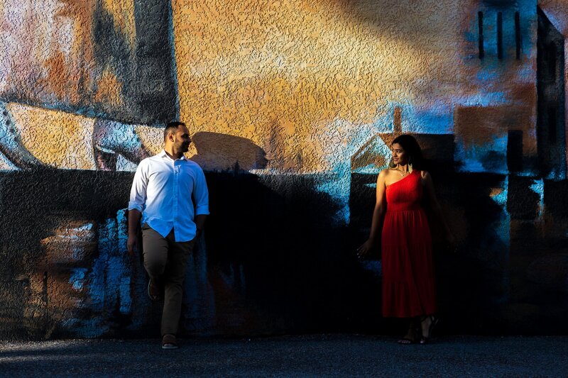 Dramatic lighting with a couple posing against a mural downtown Sarasota, Fl