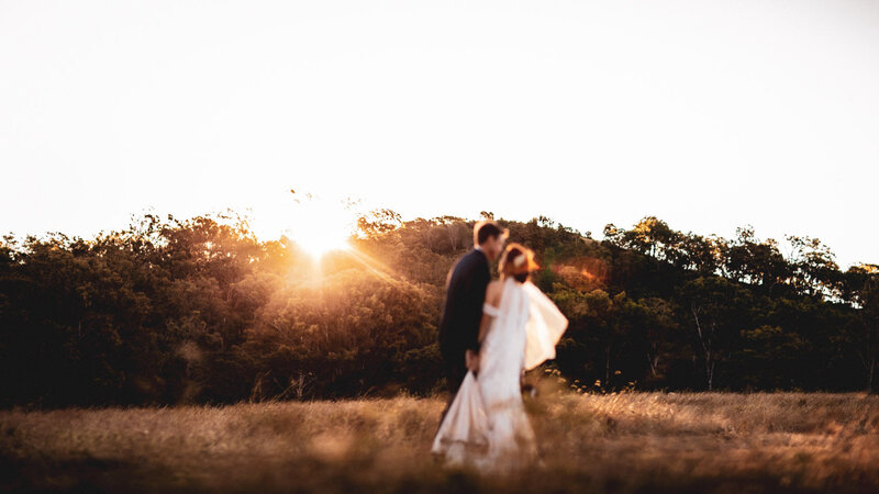Newly-weds having photo shoot during beautiful sunset at mountain top