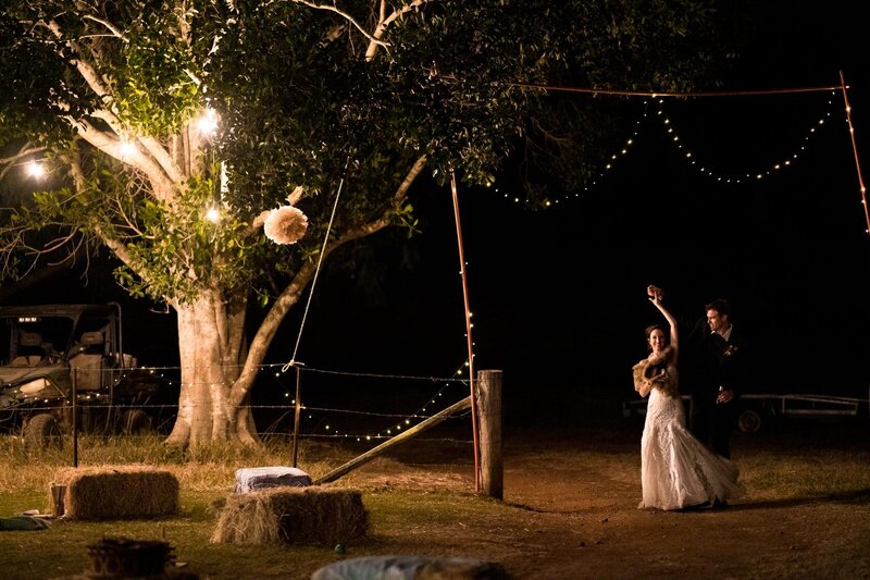 Wedding couple dancing under the tree lights