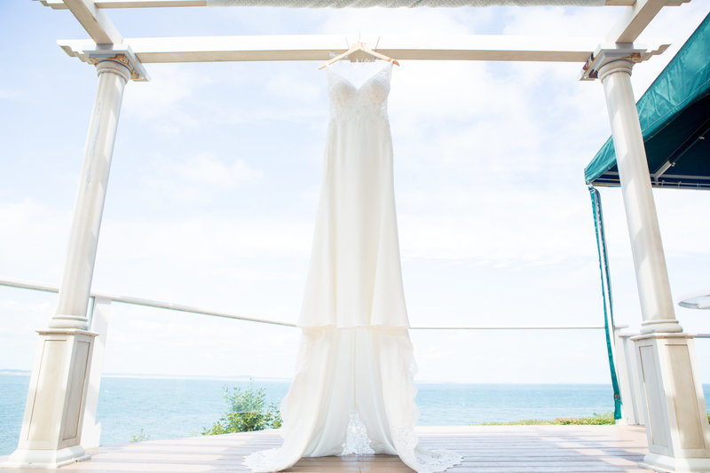 New England bridal gown hung up near beach shore