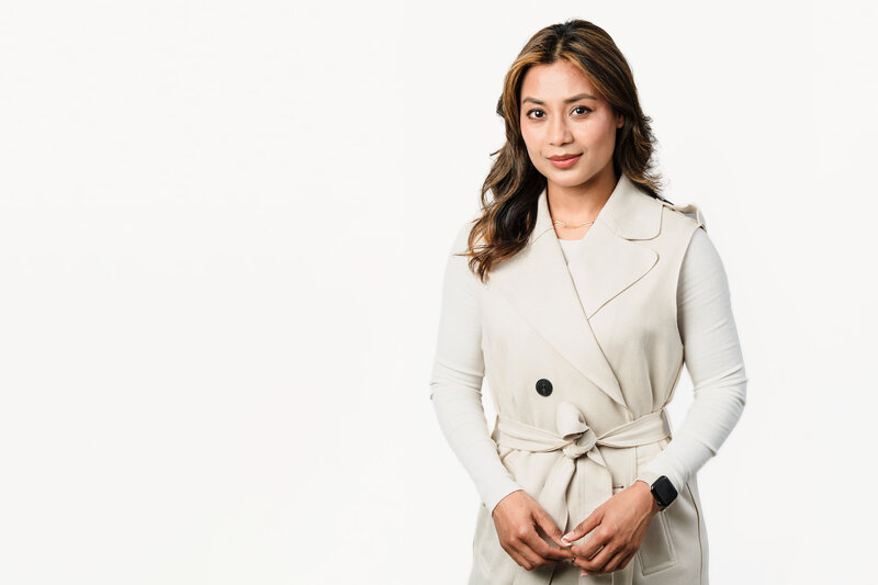 Brand Headshot for a female entrepreneur wearing a gorgeous off-white coat, in a white backdrop