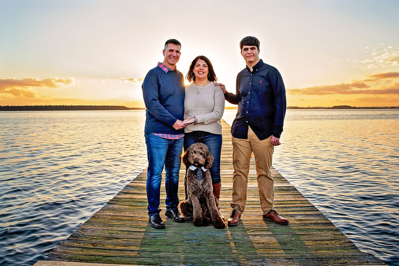Family and dog on river pier