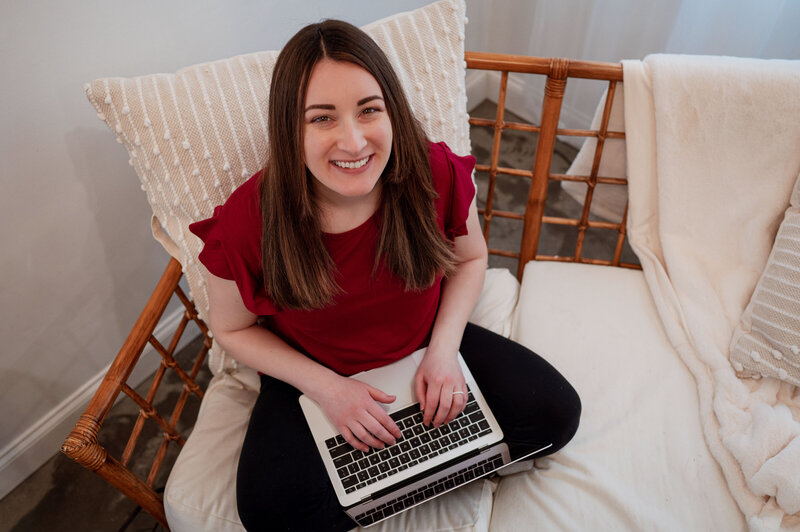 Creative businesswoman sitting on a couch working on her laptop smiling