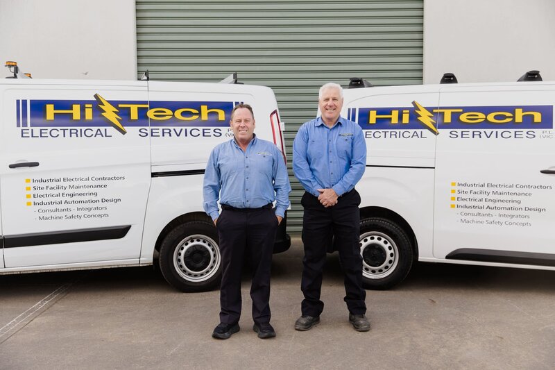 Shane and John of the industrial electrical contractors Hi Tech team standing in front of the Hi-Tech Vans
