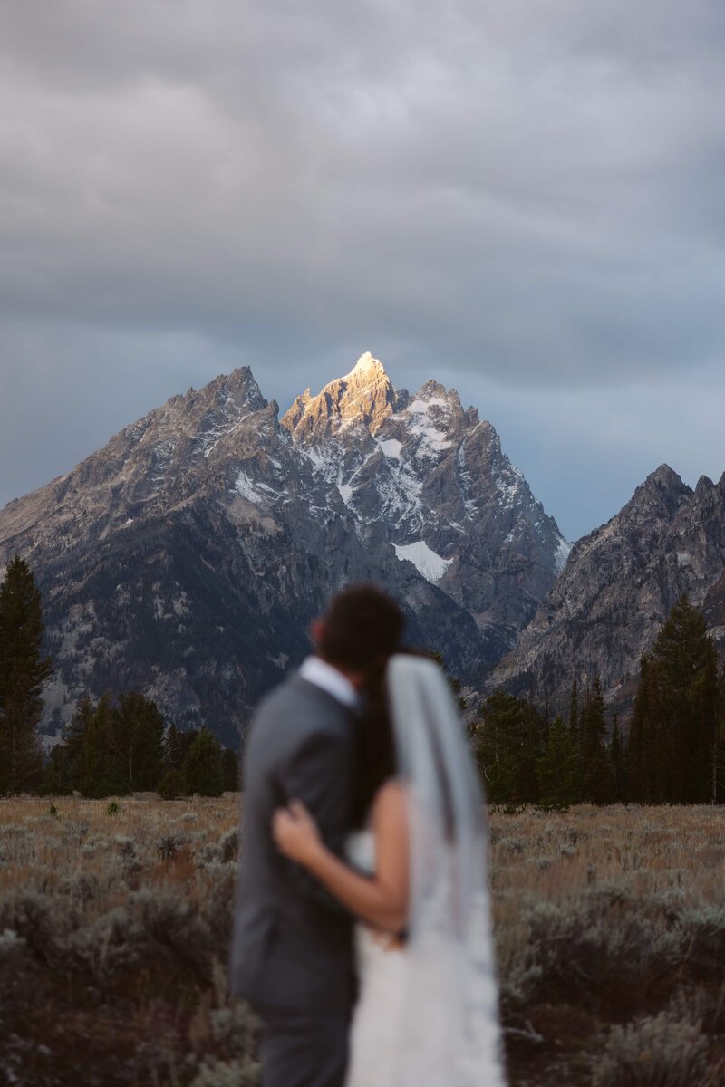 A couple saying their vows in front of the snow covered Sawtooth Mountains in Stanley, Idaho