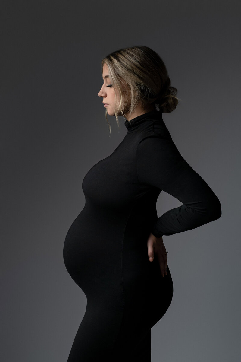 silhouette of pregnant mother in black dress