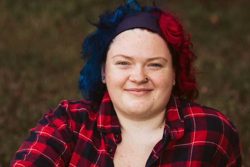 A smiling teen with curly red and blue hair Vermont Senior Portraits