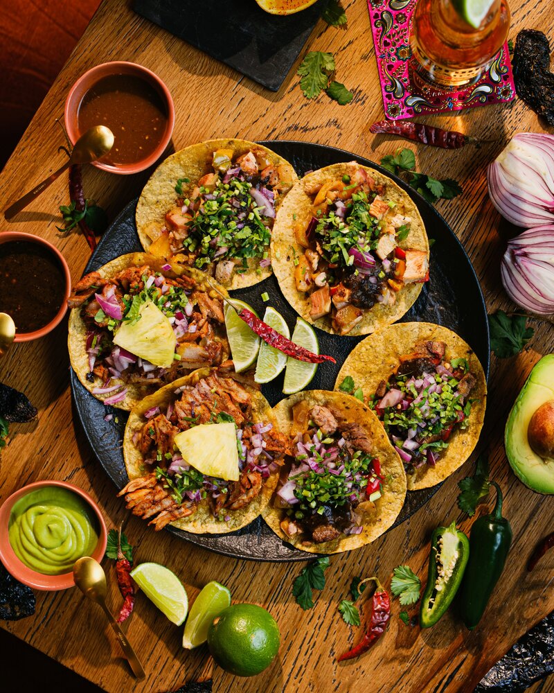 Hart and Main chicken and asada tacos with cilantro, radish and onion garnish, accompanied by limes and red and green salsas