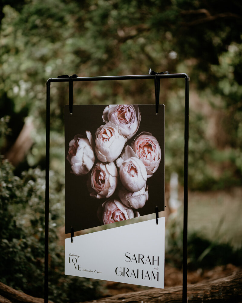 Two-piece wedding sign with large image of roses and couples names