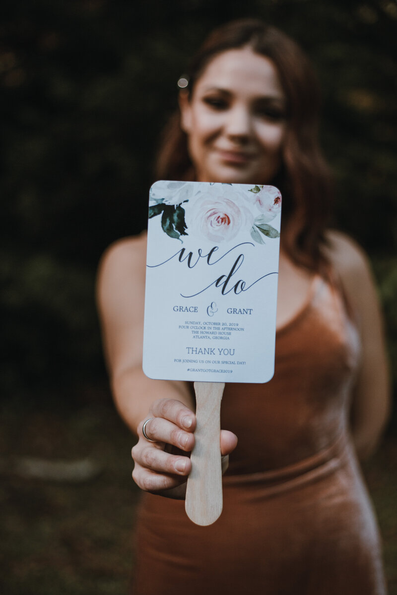 young woman in brown dress holding wedding invite